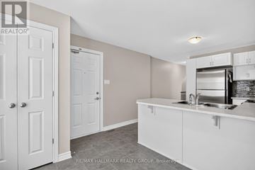 Ottawa townhouse for rent - A kitchen area with white cabinets and a stainless steel fridge.