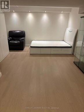 Toronto (L'amoreaux) townhouse for rent - A room with a black leather chair and a white bed.