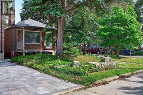 Toronto (Birchcliffe-Cliffside) apartment for rent - A small house with a brick chimney is surrounded by trees and a stone pathway.