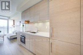 Toronto (Annex) condo for rent - A modern kitchen with wooden cabinets and a stainless steel stove.
