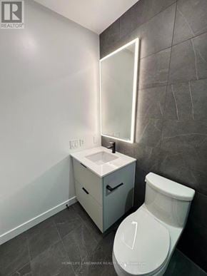 Toronto (North St. James Town) condo for rent - A white toilet sits next to a sink in a bathroom.