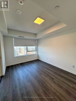 Toronto (North St. James Town) condo for rent - A room with wooden flooring and a window with blinds.
