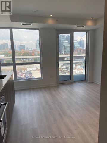 Toronto (Waterfront Communities) condo for rent - A spacious room with a view of the cityscape through large windows.