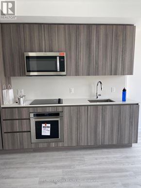 Toronto (Waterfront Communities) condo for rent - A modern kitchen with a microwave above the stove.