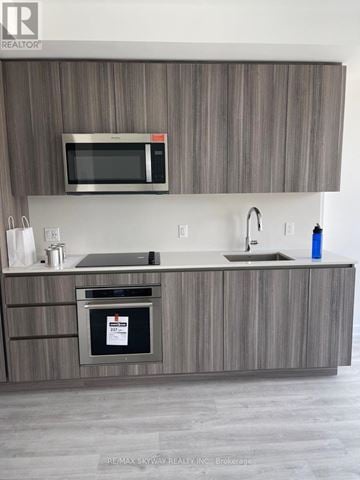 Toronto (Waterfront Communities) condo for rent - A modern kitchen with a microwave above the stove.