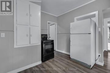 St. Thomas multi-family for rent - A white refrigerator in a kitchen with a black stove and cabinets.