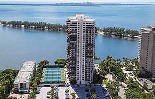 Mia apartment for rent - A tall white building with a pool in front of it.