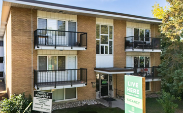 Edmonton apartment for rent - A two-story apartment building with a sign that says "Live Here" and "Vacancy".