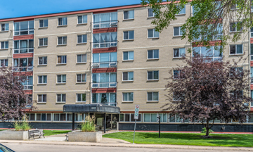 Edmonton apartment for rent - A large apartment building with a tree in front.