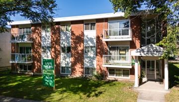 Edmonton apartment for rent - A red brick building with a green sign that says "Live Here".