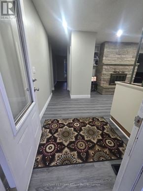 Clarington (Courtice) apartment for rent - A hallway with a rug on the floor and a fireplace in the background.