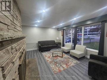 Clarington (Courtice) apartment for rent - A living room with a grey couch and a stone wall.