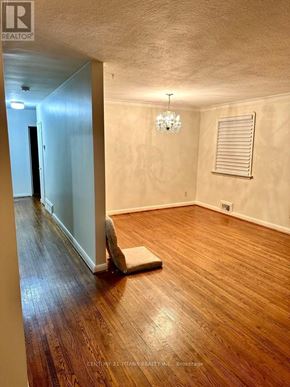 Toronto (Wexford-Maryvale) apartment for rent - A room with wooden floors and a chandelier.