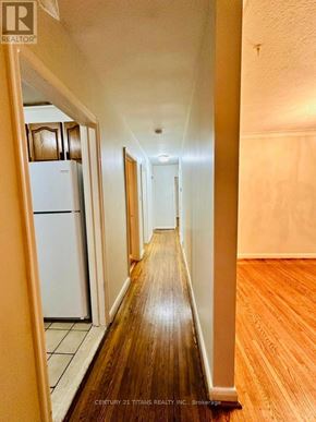 Toronto (Wexford-Maryvale) apartment for rent - A long hallway with wood floors and white walls.
