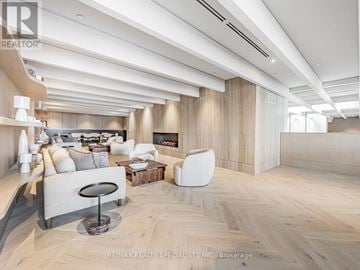 Vaughan (Vaughan Corporate Centre) condo for rent - A spacious living room with a curved sofa and a coffee table.