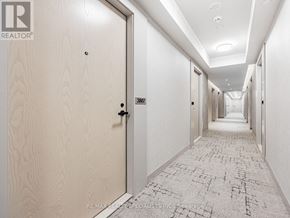 Vaughan (Vaughan Corporate Centre) condo for rent - A hallway with a tiled floor and a series of doors on one side.