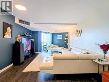 Windsor condo for rent - A living room with a white couch and a television.