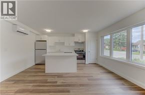 Kitchener apartment for rent - A well-lit kitchen with wooden flooring and white cabinetry.