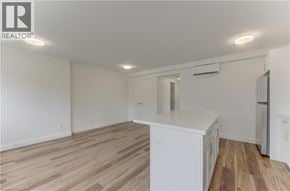 Kitchener apartment for rent - A kitchen with white cabinets and a wooden floor.