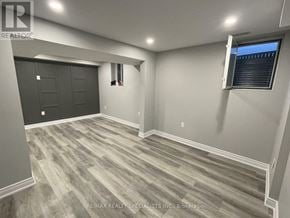 Barrie (Georgian Drive) apartment for rent - A room with a grey floor and a black door.