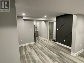 Barrie (Georgian Drive) apartment for rent - A room with a grey floor and a black door.