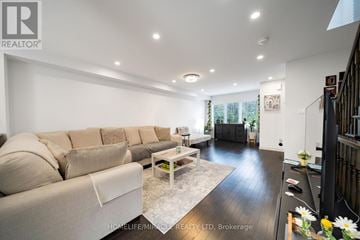 Hamilton (Stoney Creek Mountain) townhouse for rent - A spacious living room with a large sectional sofa and a coffee table.