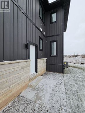 Niagara Falls (Brown) apartment for rent - A house with a black exterior and a white door is shown.