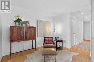 Collingwood condo for rent - A living room with a brown leather chair and a wooden cabinet.
