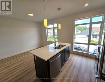 Ottawa multi-family for rent - A kitchen with a sink and a window overlooking a parking lot.