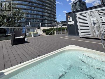 Toronto (Waterfront Communities) condo for rent - A hot tub on a wooden deck with a cityscape in the background.