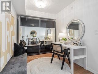 Toronto (Yorkdale-Glen Park) condo for rent - A living room with a grey couch and a white desk with a round mirror above it.