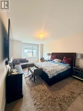 Oakville (Jm Joshua Meadows) townhouse for rent - A bedroom with a large bed and a flat screen TV.