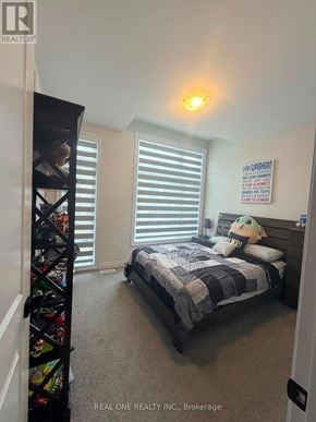 Oakville (Jm Joshua Meadows) townhouse for rent - A bedroom with a bed, a bookshelf, and a poster on the wall.