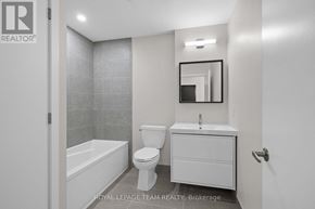 Ottawa condo for rent - A white bathroom with a toilet, sink, and bathtub.
