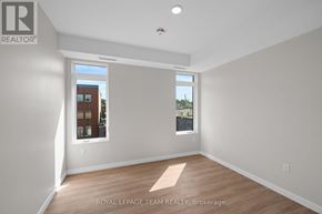 Ottawa condo for rent - A room with a window showing a view of a building with the text "ROYAL LEPAGE TEAM REALTY, Brokerage" on the wall.