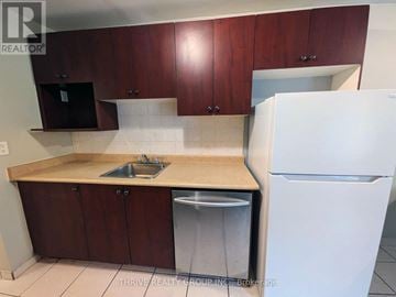 London South (South M) condo for rent - A kitchen with brown cabinets and a white refrigerator.