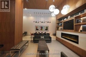 Toronto (Waterfront Communities) condo for rent - A modern living room with a fireplace and a TV mounted on the wall.