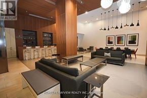 Toronto (Waterfront Communities) condo for rent - A modern living room with a bar area and a kitchen in the background.