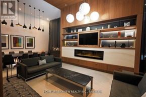 Toronto (Waterfront Communities) condo for rent - A modern living room with a fireplace and a coffee table.