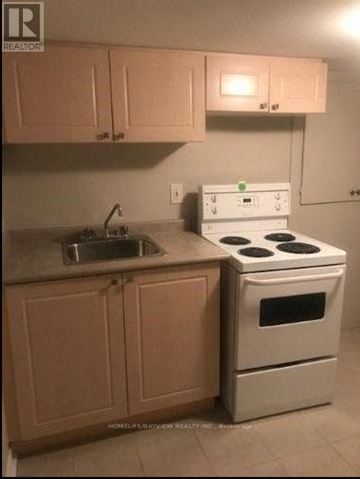 Richmond Hill (Oak Ridges Lake Wilcox) apartment for rent - A kitchen with a stove, sink, and cabinets.