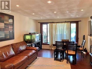 Toronto (Willowridge-Martingrove-Richview) apartment for rent - A living room with a brown leather couch and a fish tank.