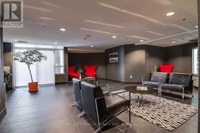 Toronto (Dovercourt-Wallace Emerson-Junction) condo for rent - A living room with a black couch and a red chair.