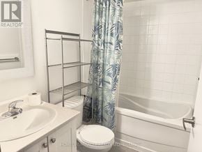 Toronto (Dovercourt-Wallace Emerson-Junction) condo for rent - A bathroom with a white tub, sink, and toilet.