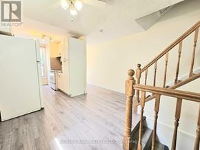 Cambridge apartment for rent - A room with a staircase and a refrigerator.