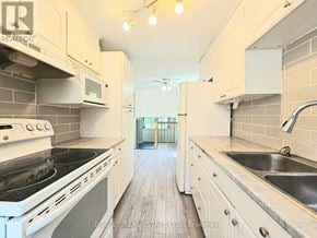 Cambridge apartment for rent - A kitchen with white cabinets and a black stove top.