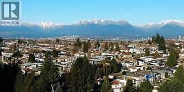 Vancouver apartment for rent - A cityscape with houses and trees in the foreground and snow-capped mountains in the background.