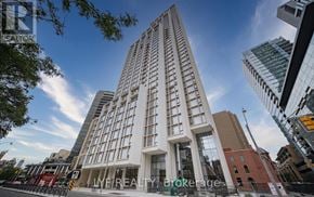 Toronto (Annex) condo for rent - A tall white building with the words "IMF REALTY Brokerage" on the front.