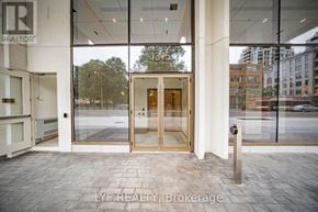 Toronto (Annex) condo for rent - The entrance to a building with a glass door and a sign that reads "13th St.".