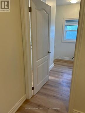 Thorold (Thorold Downtown) apartment for rent - A white door is open in a hallway with wooden floors.