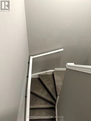 Guelph (Grange Road) townhouse for rent - A staircase with a carpeted runner and white handrail.